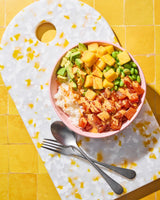 Salmon poke bowl with avocado, mango, edamame and sriracha mayo